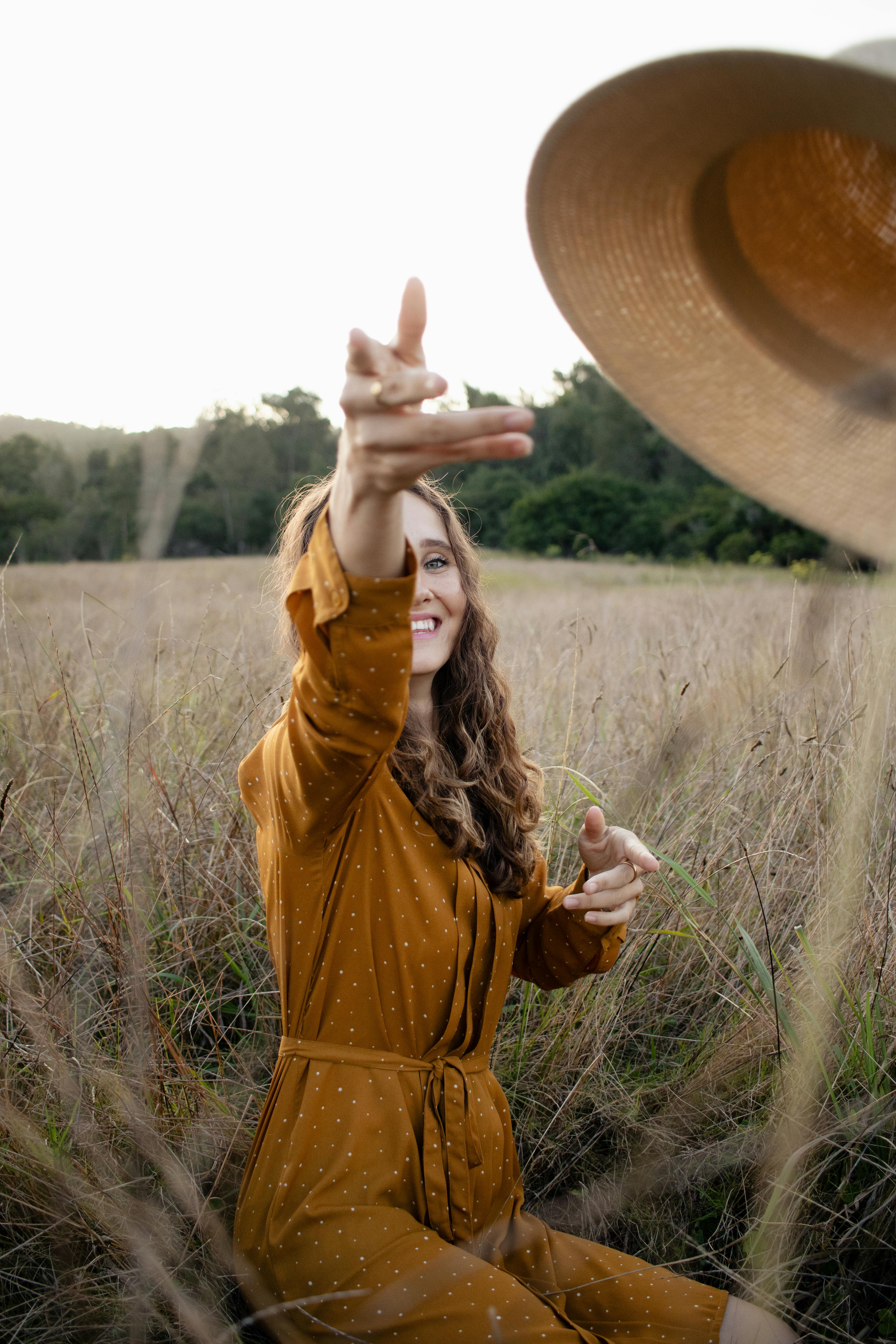 A woman reaching for her hat